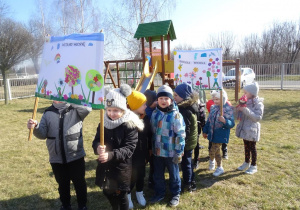 Dzieci maszerują z plakatami wiosennymi.